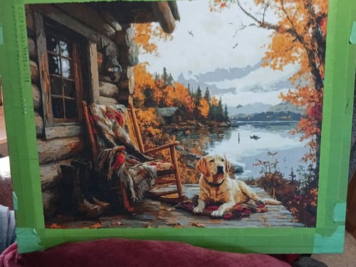 Reviewer's completed 'The Loyal Rest' paint by numbers, showing a dog on a cabin porch overlooking a lake.