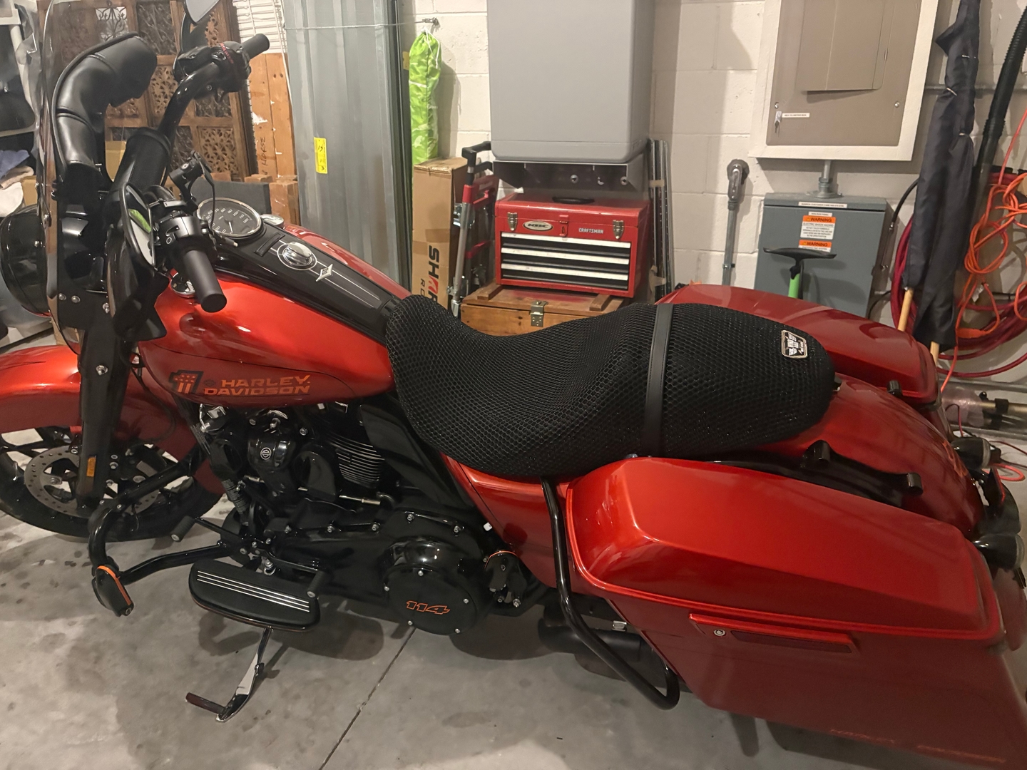 Harley Electra Glide with Wind Rider raised 3D mesh seat cover installed in motel parking lot, airflow gap visible beneath
