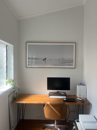 Reviewer's panoramic Summer Days art print in a light wood frame, hanging above a desk in a home office space.