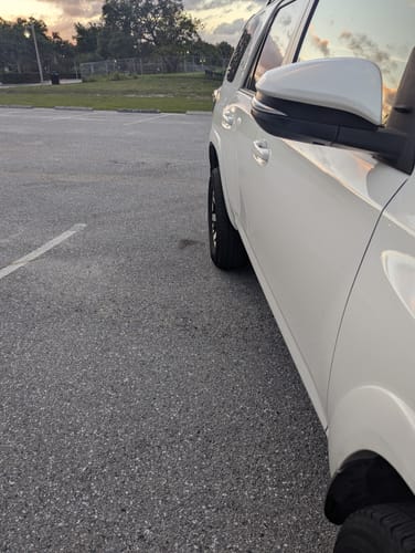 Reviewer's white SUV parked, showing the wider wheel stance created by the 1.25-inch hubcentric wheel spacers.