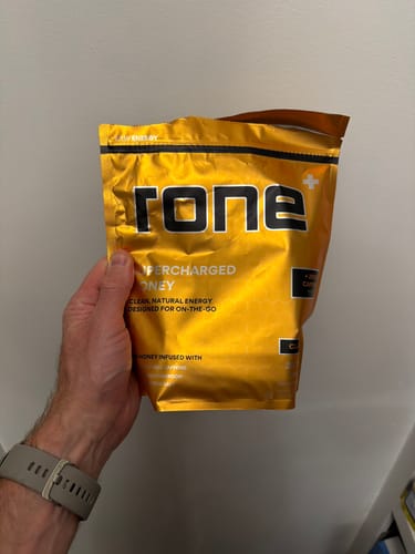 Reviewer holding the yellow pouch of SuperCharged Honey.
