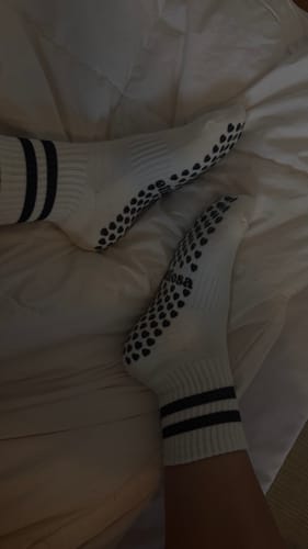 Reviewer's feet wearing the white Dual-Direction Grip Stripes socks, showing the black grips on the bottom.