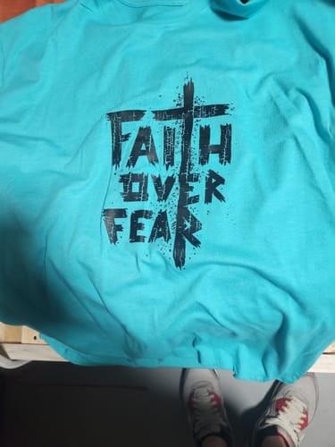 Customer's teal Faith Over Fear Tee laid out, showing the distressed black 'Faith Over Fear' graphic.