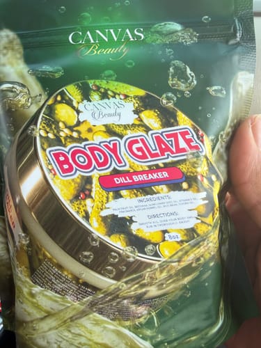 Customer holding the DILL BREAKER Body Glaze in its green branded pouch.