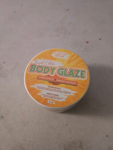 Reviewer's 2oz travel edition jar of Pineapple Upside Down Body Glaze on a flat surface.