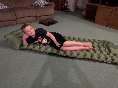 Child resting on the Adventure Mat indoors