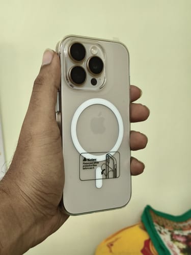 Customer holding a phone with the transparent Anti Yellow Clear Case, showing the back and MagSafe ring.
