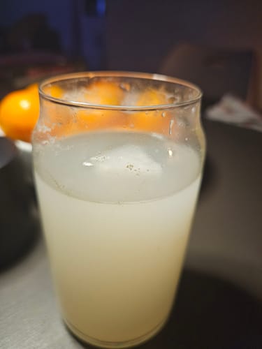 Customer's glass of Kava Drink Mix, prepared as a cloudy, pale liquid.