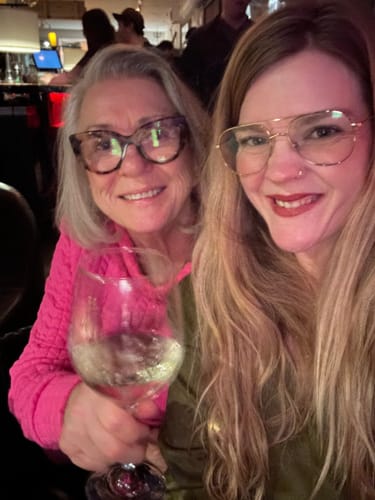 Reviewer smiling with another person, showing her skin results from using the Seranova Micro Infusion System.