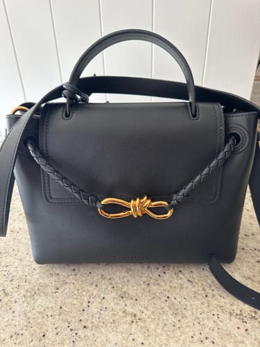 Customer's black BV Ciao Ciao Medium Bag on a counter, showing its braided detail and gold knot clasp.