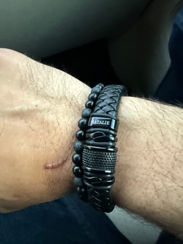 Reviewer's personalized black bracelet with the name 'NATALIE' engraved, shown on their wrist.