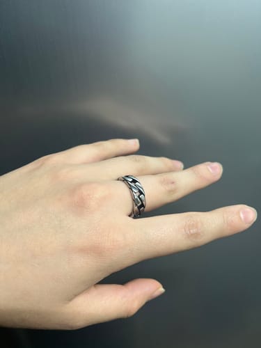 Un cliente mostrando el Anillo Box en su mano, que tiene un diseño de cadena plateada.