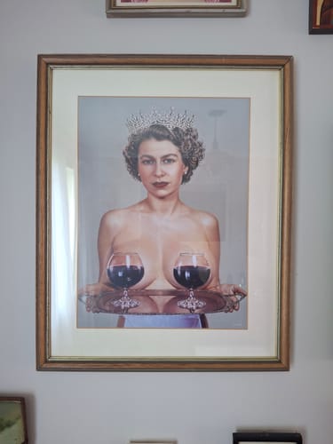 Reviewer's framed 'Majestic' art print on a wall. The piece shows a woman in a crown holding a tray with two glasses of wine.