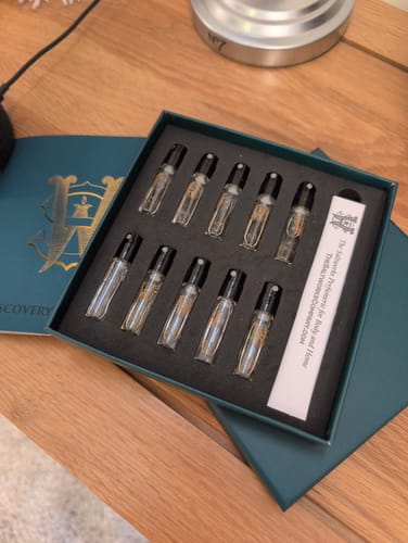Customer's Discovery Set open in its dark green box, showing the ten fragrance sample vials inside.