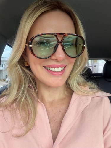 Cliente usando os óculos Tropea com armação tartaruga e lentes verdes dentro de um carro.