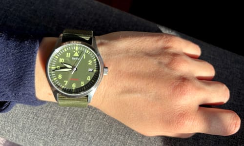 Anmelder som viser Far-Far Automatisk Pilotklokke med grønn reim på håndleddet.