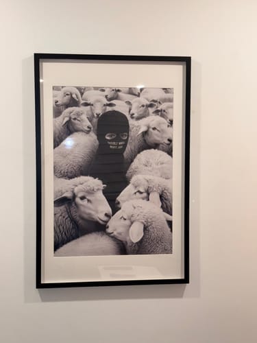 Customer's 'Built Different' art print in a black frame with a white mat, hanging on a wall.