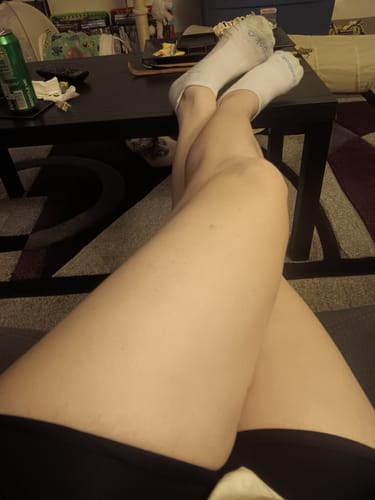 Reviewer resting with their smooth legs crossed, showing the top of the black 3D Anti-Cellulite Leggings on their thighs.