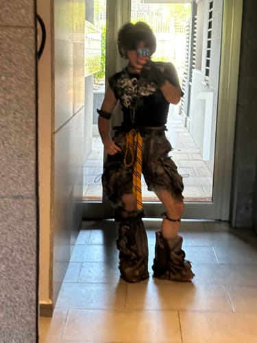 Reviewer shows the long fit of the Personsoul Black Detachable Denim Overalls, which are bunched around the ankles.