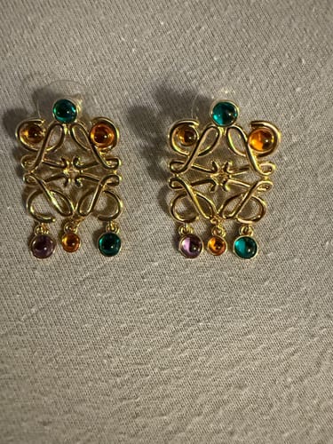 Customer's ANAGRAM MULTICOLOR GOLD LARGE EARRINGS laid flat, showing the detailed gold design and colorful stones.