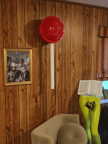 Customer's framed AREA 51 art print hanging on a wood-paneled wall in an eclectic room.