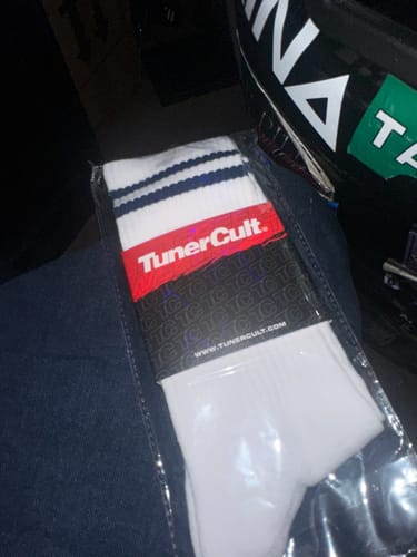 Customer holding the M-POWER SOCKS in their packaging, showing the white sock with blue stripes at the top.