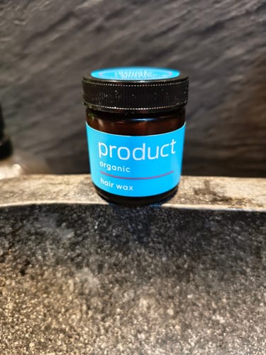 Customer's Product Organic Hair Wax jar with a bright blue label, shown on a stone surface.