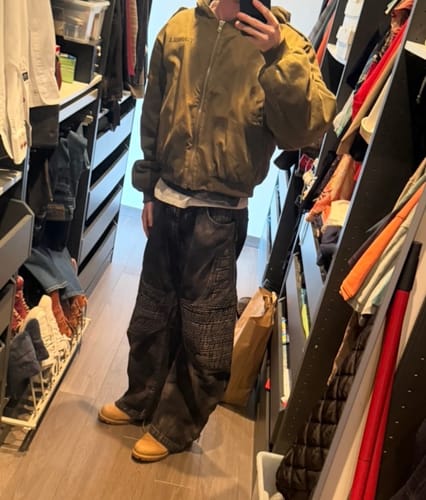 Reviewer in a closet wearing dark Temperature-Reactive Curved Jeans with a brown jacket.