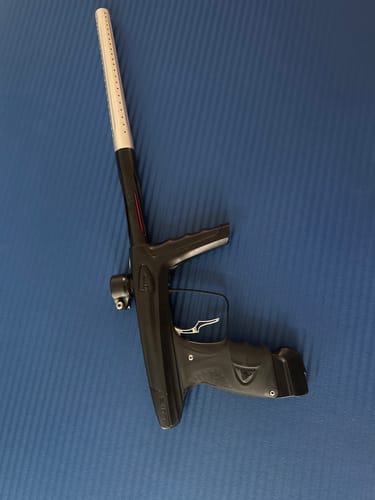 Customer's silver LUXE DEUCE TRIGGER TYPE S installed on a black paintball marker, lying on a blue surface.