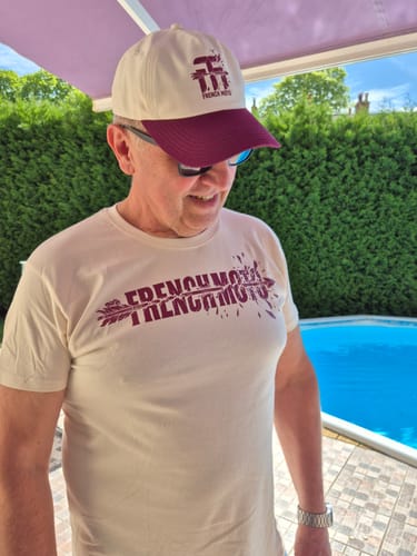 Client portant le t-shirt couleur naturelle et la casquette bicolore de la COLLECTION ARROW en extérieur.
