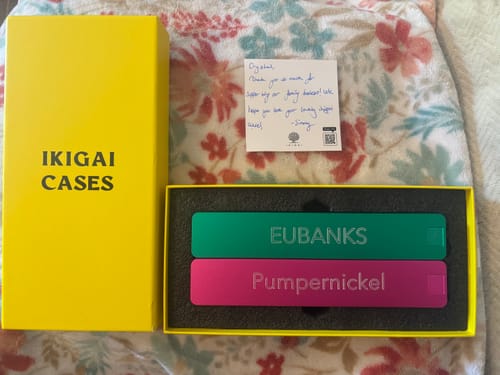 Customer's personalized green and pink Vitamin Cases in the product packaging with a handwritten note.