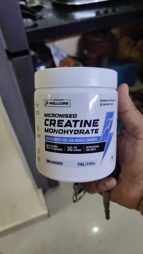 Reviewer holding the white container of Wellcore Micronised Creatine Monohydrate.