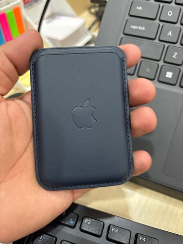 Reviewer holding the deep blue Signature Leather Magsafe Wallet in their palm, showing the smooth finish.