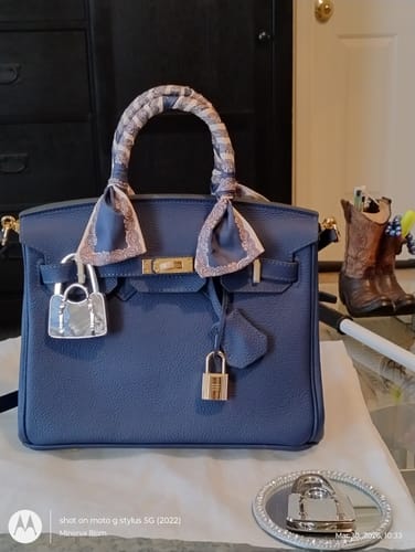 Reviewer's blue LALUVA Warkin Bag with a decorative scarf on the handle, showing the gold lock hardware.