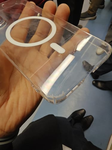 Customer holds the Anti Yellow Magsafe Clear Case, showing minor scratches on the corner after it was run over by cars.