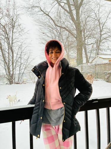Reviewer with glowing skin from using Deep Collagen Cream, smiling while standing in a snowy backyard.