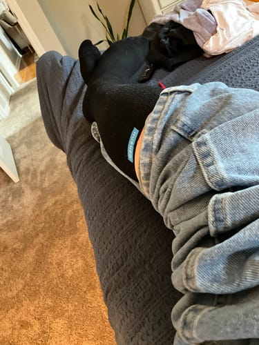 Reviewer relaxing with their leg up, wearing a black Performance Eucalyptus Compression Sock.