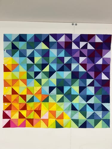 Reviewer's Color Study quilt top in progress, showing the colorful triangular pieces forming a gradient.