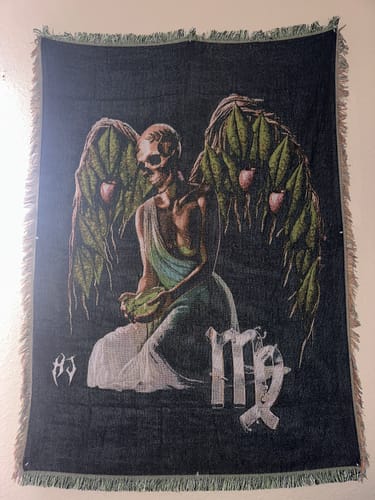 Customer's Virgo Zodiac Tapestry with a skeletal angel design hanging on a light-colored wall.