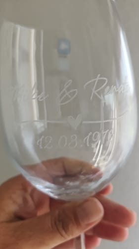 Rezensent hält ein Leonardo Glas, um die persönliche Gravur mit Namen, Herz und Datum aus der Nähe zu zeigen.