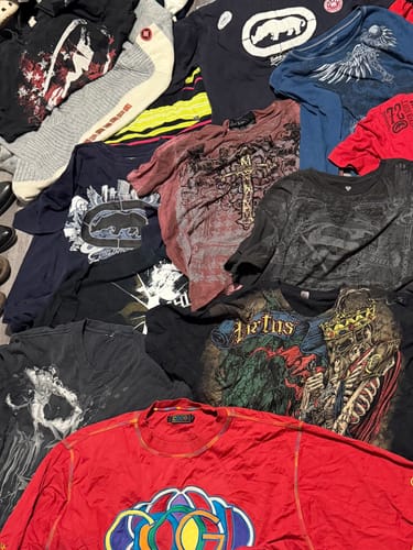 Customer's large pile of Y2K Men's T-Shirts, showing various colorful graphic prints.