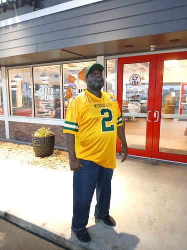 Customer wearing the gold and green custom football jersey with the number 2.