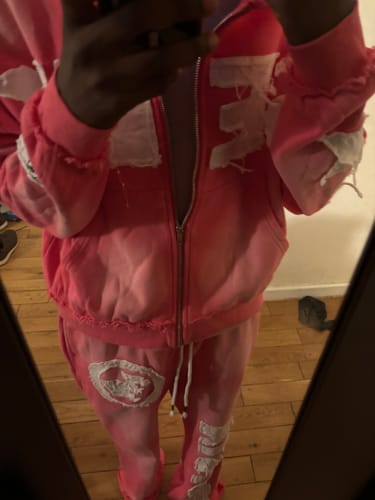 Customer takes a mirror photo wearing the pink distressed SEEK VISIONZ SET.