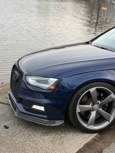 Reviewer's blue Audi parked near water, showing the wider stance from the installed 12MM hubcentric wheel spacers.