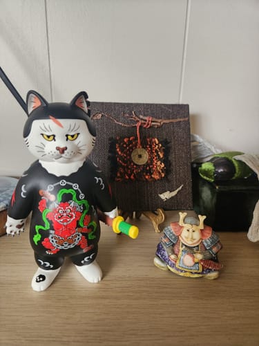 Customer's fierce Donburi Toy figurine with its detailed red tattoo and sword, displayed on a wooden shelf.