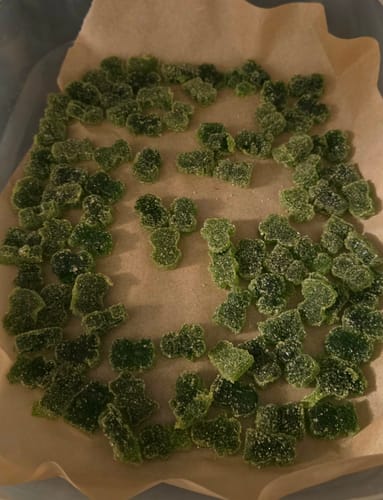 Customer's large batch of homemade green gummies made using the Exotic Shake, laid out on parchment paper.