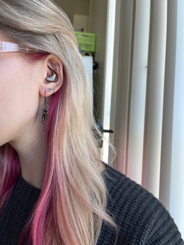 Customer wearing the silver Moth Septum jewelry in their daith piercing.