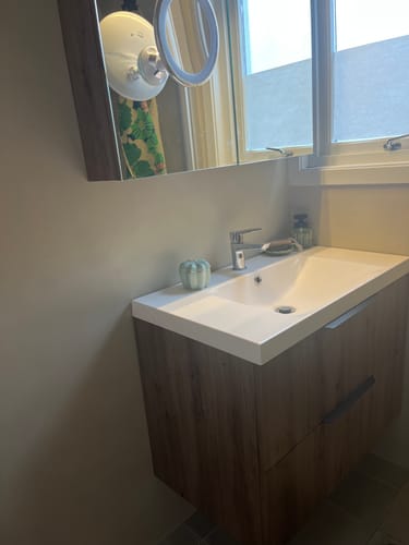 Kundens servantskap og speilskap på badet dekket med varm Artisan Oak kontaktplast.