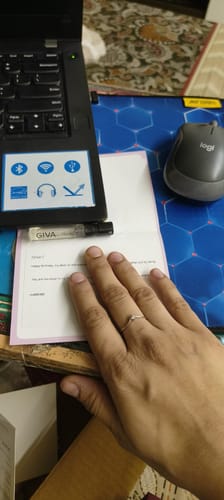 Customer's hand wearing the delicate Silver Sparkling V Ring on their ring finger, resting on a desk.