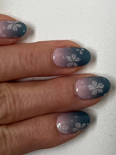 A customer's nails with Holy Gels featuring a pink-to-teal gradient design and white floral art.